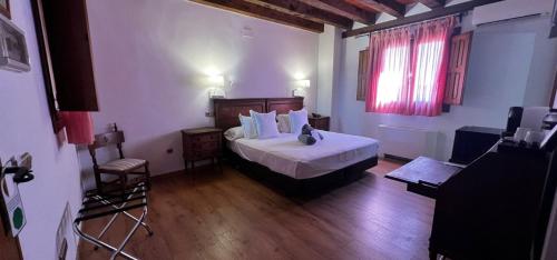 a bedroom with a bed in a room with wooden floors at Hospedium Hotel Rural Abadía de Yuste in Cuacos de Yuste