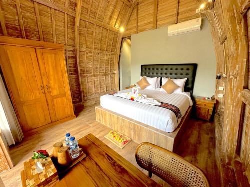 a bedroom with a bed and a table in it at Nature Stay Uluwatu in Uluwatu