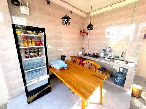 a kitchen with a wooden table and a refrigerator at Nature Stay Uluwatu in Uluwatu