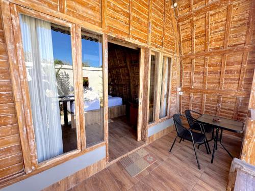 a room with a table and windows in a cabin at Nature Stay Uluwatu in Uluwatu
