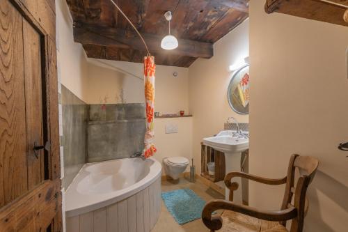 a bathroom with a tub and a toilet and a sink at Les chambres de la ferme de chalas in Valgorge