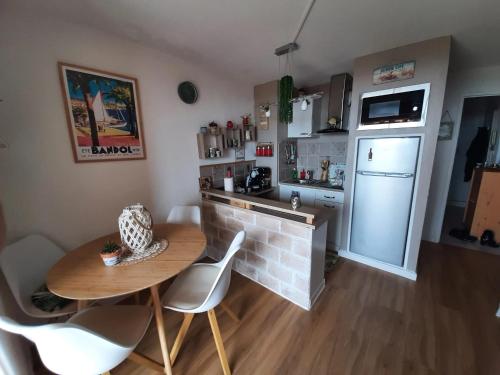 a small kitchen with a table and a refrigerator at Appartement charmant à Bandol 30 m² avec vue sur la mer. in Bandol