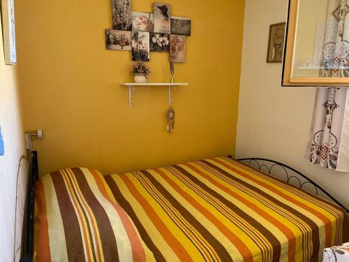 ein Schlafzimmer mit einem Bett mit gelber Wand in der Unterkunft Appartement charmant à Bandol 30 m² avec vue sur la mer. in Bandol