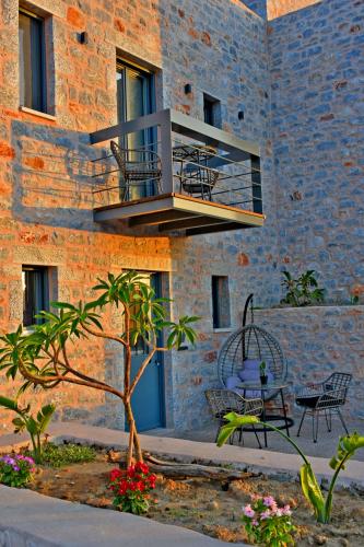 a building with a balcony and a table and chairs at Opuntia Boutique Hotel in Kalívia