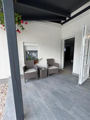 a patio with two chairs and a table and a mirror at Adél Apartman in Kisújszállás