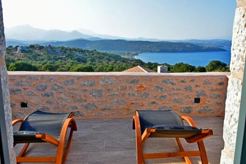 two chairs sitting on a balcony looking out at the water at Opuntia Boutique Hotel in Kalívia