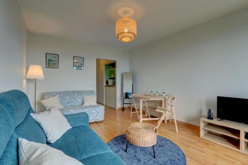 un salon avec un canapé bleu et une table dans l'établissement L'Écrin d'Elteville - Charmant studio, à Montrichard