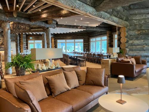 a living room with a couch and a dining room at HUNURIJÄRVI RESORT***** in Härmä