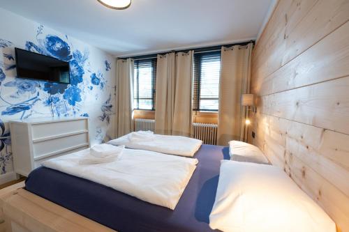 a bedroom with two beds and a wall with a tv at ALPENLIEBE - Sauna & Whirlpool - APARTments in Inzell