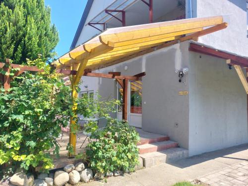 a building with a yellow awning on it at Oázis Vendégház és Appartman in Szilvásvárad