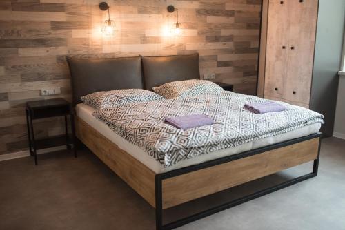 a bedroom with a bed with a wooden wall at Penzion Moon in Ostrava