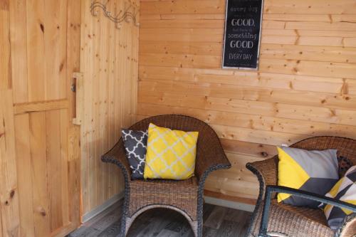 two wicker chairs with pillows on a porch at Ferienhaus Seeblick in Twist