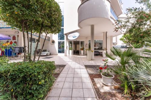 a walkway in front of a building with plants at Residence Marconi Mare in Rimini