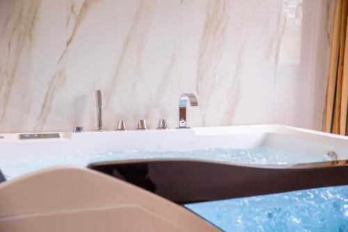 a bathroom with a bath tub with a sink at Hotel Palace Savuto in Malito