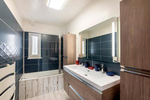 une salle de bain avec un lavabo et un miroir dans l'établissement Urban Comics - Appt climatisé 10p proche de Paris, à Brétigny-sur-Orge