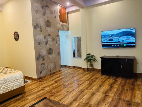 a room with a bed and a tv on a wall at Bhanu bhawan in Jaipur