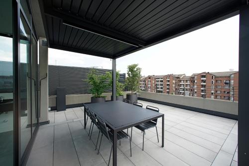 a patio with a table and chairs on a balcony at EDIT Lofts in Turin