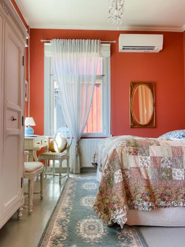 a bedroom with orange walls and a bed and a desk at Hotel Onni in Porvoo