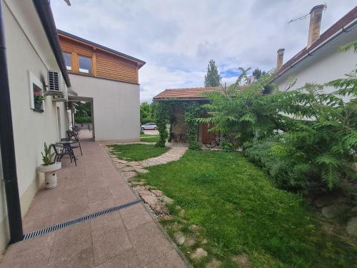 a backyard of a house with a grass yard at Kossuth Apartmanház in Tata