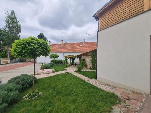 a house with a yard with a tree at Kossuth Apartmanház in Tata