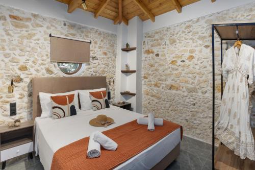 a bedroom with a bed and a stone wall at Anassa Luxury Apartment 13 in Heraklio Town