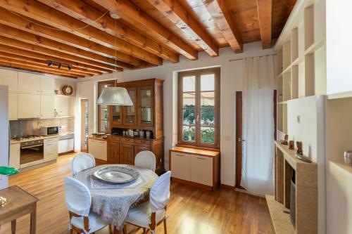 Una cocina y un comedor con mesa y sillas. en Giardino Giusti Home, en Verona