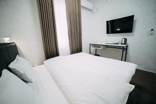 a hotel room with two beds and a television at Central Plaza Hotel in Urganch