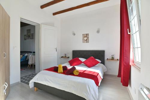 une chambre avec un lit avec des oreillers rouges dans l'établissement Spacieux T2 - proche centre - confort et sérénité, à Saint-Quentin