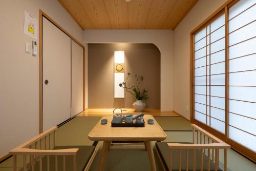 a hallway with a table and chairs in a room at Shirakabanoyado - HATSUMI, 白樺の宿 - 初美 in Osaka