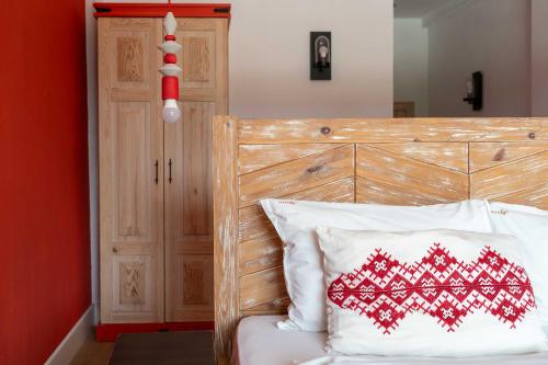 a bed with a wooden headboard and a red and white pillow at Hotel Casa Art in Oreshak