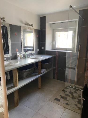 une salle de bain avec deux lavabos et une douche dans l'établissement La Bergerie, à Saint-Rome-de-Cernon