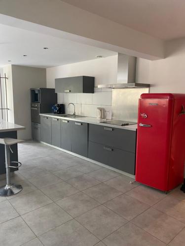 Il comprend une grande cuisine équipée d'un réfrigérateur rouge. dans l'établissement La Bergerie, à Saint-Rome-de-Cernon