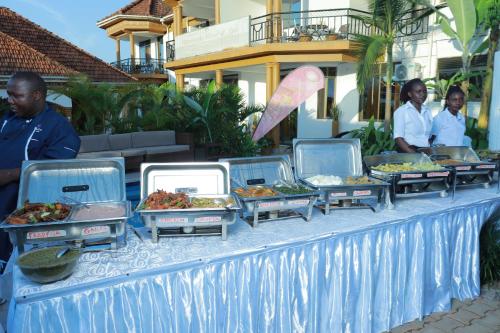 a buffet of food on a table in front of a building at Mowicribs Hotel and Spa in Entebbe