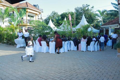 a group of people standing in front of a wedding ceremony at Mowicribs Hotel and Spa in Entebbe