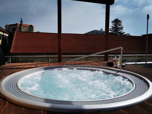 a jacuzzi tub on a wooden deck at Kníže Ferdinand Apartments in Mikulov