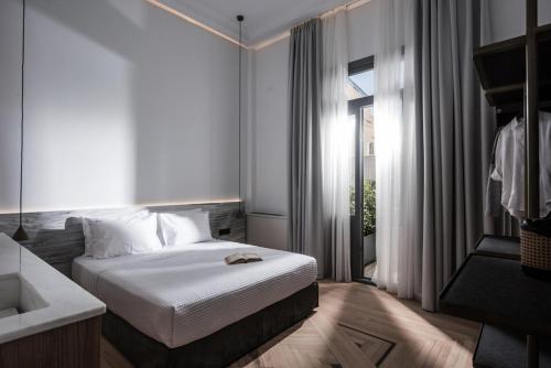a hotel room with a bed and a window at Vegga Suites in Heraklio Town