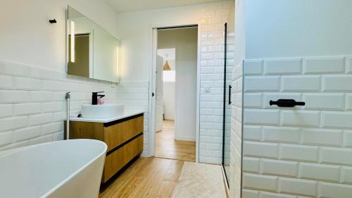 a bathroom with a tub and a sink and a shower at Villa à la plage - au coeur de Stella-Plage in Stella-Plage