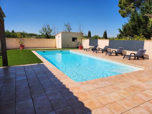 une piscine dans une cour avec des chaises autour dans l'établissement DOMAINE DE POULHARIES -Merlot, à Carcassonne