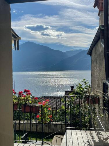 a balcony with flowers and a view of the water at Nobiallum B&B in Menaggio