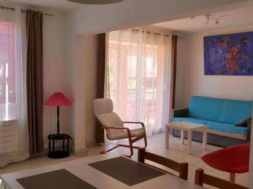 un salon avec un canapé bleu et une chaise dans l'établissement Appartement 60m2 - 2 Chambres à une minute des plages, parking privé, à Sausset-les-Pins