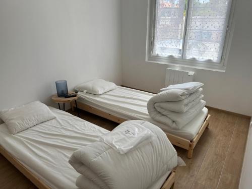 deux lits jumeaux dans une chambre avec fenêtre dans l'établissement maison agréable et calme dans ile oleron, au Château-dʼOléron