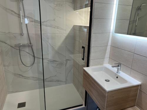 une salle de bain avec un lavabo et une douche dans l'établissement maison agréable et calme dans ile oleron, au Château-dʼOléron