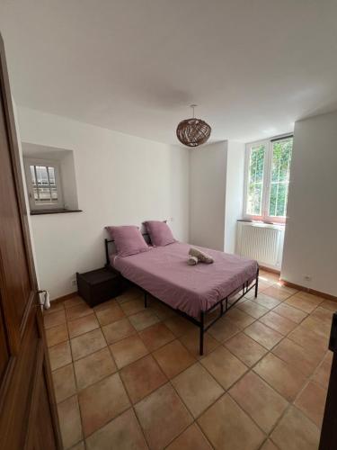 - une chambre avec un lit recouvert de draps violets dans l'établissement Appartement et jardin vals les bains, à Vals-les-Bains