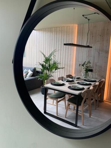 a dining room with a table and chairs in a mirror at Widać Wydmy in Łeba