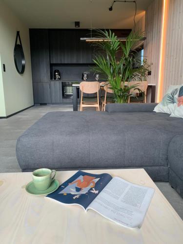 a coffee table with a book and a cup on it at Widać Wydmy in Łeba
