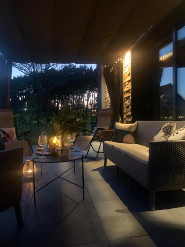 a living room with a couch and a table at night at Widać Wydmy in Łeba