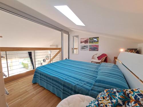 a bedroom with a bed and a large window at Magarà Apartment by Casa in mente in Cefalù