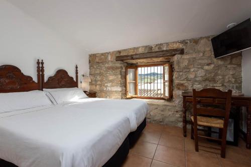 A bed or beds in a room at Tugasa Hotel y Apartamentos rurales La Posada