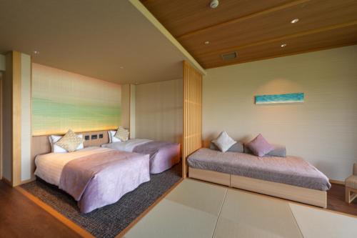 two beds in a hotel room with at KAMENOI HOTEL Toba in Toba