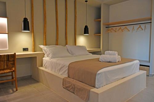 a bedroom with a bed and a desk and lights at Opuntia Boutique Hotel in Kalívia